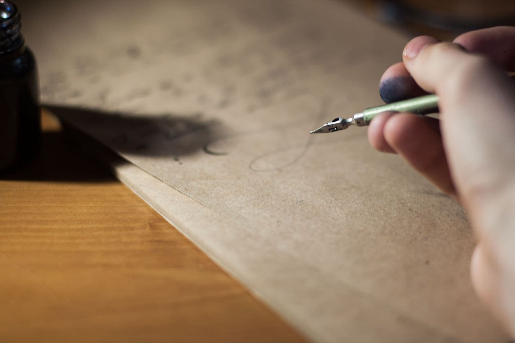A hand writing a letter with a fountain pen.