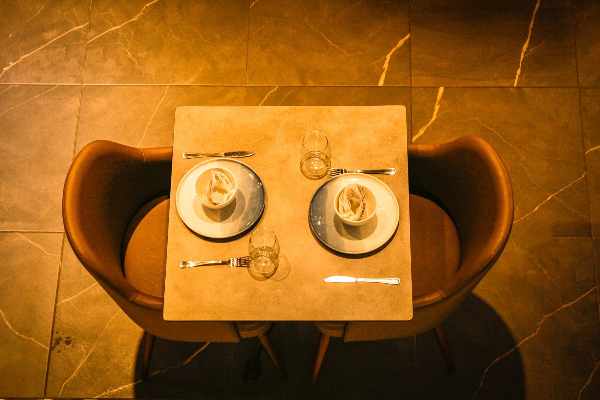A restaurant table set for two, seen from above.